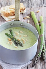 Asparagus cream soup with pine nuts and asparagus topping