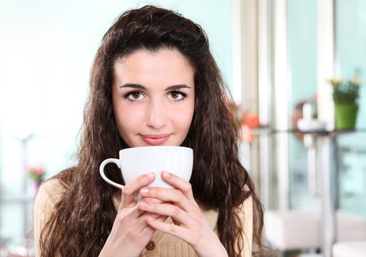 girl smiling in coffee drink with cup in hand