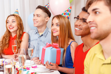 Young people celebrating a birthday sitting at the table