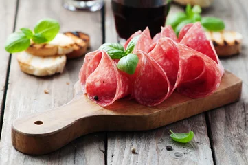 Fototapeten Delicious salami with basil and wine © nolonely