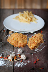 fried chicken wings with french fries on wood table.