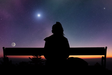 Obraz premium Girl watching the Moonrise on a starry skies.