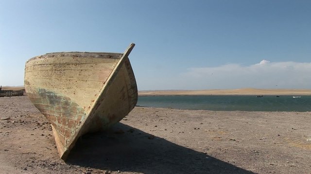 Old fishing boat in desert of Paracas National Park, Peru