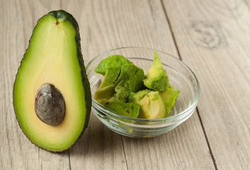 Halved avocados on rustic wooden background