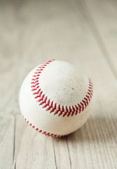 Old baseball on wooden background and highly closeup