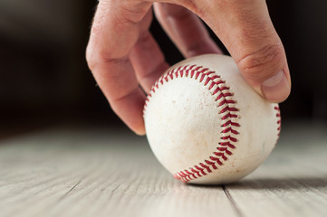 Old baseball on wooden background and highly closeup