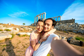 Tourist young couple near Poseidon temple in Greece