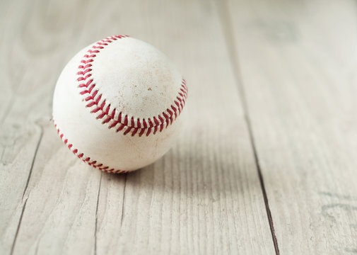 Old baseball on wooden background and highly closeup
