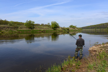Fototapeta na wymiar fisherman with a fishing rod on the river