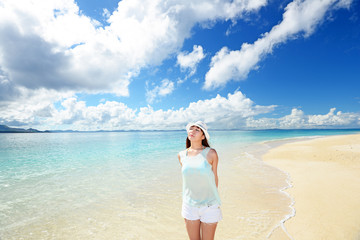 Fototapeta na wymiar 水納島のビーチで遊ぶ笑顔の女性 