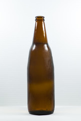 Bottle of beer with drops on white background.