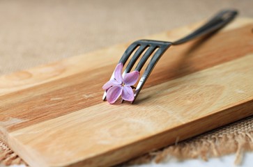 fork with flower wooden plank on table breakfast