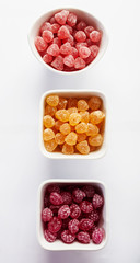 Fruity jelly beans sprinkled with sugar on white background