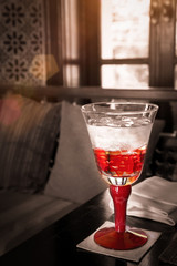 Red Glass Of Water On The Table With Sun Light : Selective Focus