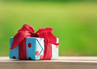 gift box on wooden table on natural sunny background