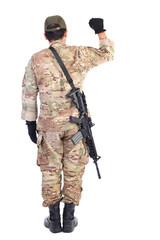 Back view of a soldier with gun holding his arm up