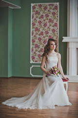 Fototapeta premium The girl in a smart dress sits on a chair in a hall 2666.