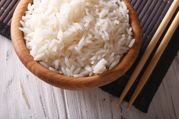 Asian food: rice in a wooden bowl closeup. horizontal top view
