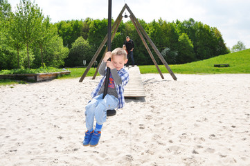 Fröhlicher Junge beim Spielen auf einem Spielplatz