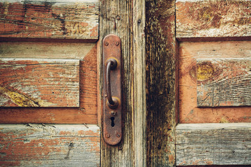wooden wall and a door with an old rusty lock