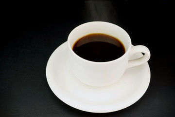Obraz na płótnie Canvas white cup with hot liquid and steam on black