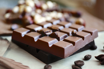 Chocolate with coffee beans on paper, closeup