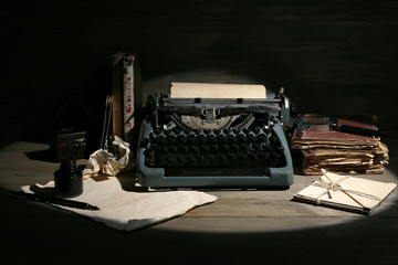 Retro typewriter in lamplight on wooden background