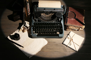 Retro typewriter in lamplight on wooden background