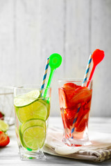 Cocktails with fresh strawberries and lemon lime on wooden background