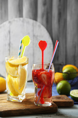 Cocktails with fresh strawberries and lemon lime on wooden background