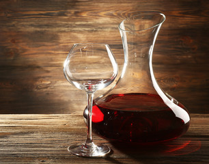 Glass carafe of wine on wooden background