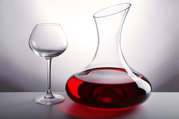 Glass carafe of wine on light background