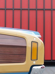 Amerikanischer Station Wagon mit Holzdekor und Katzenauge der Siebzigerjahre vor roter Fassade im...