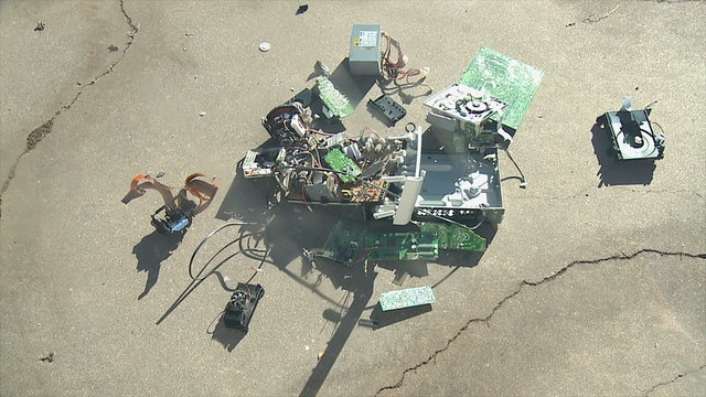 Electronic Components Crash. A pile of broken electronic and computer components is dropped onto concete. Shot in slow motion at 60fps.