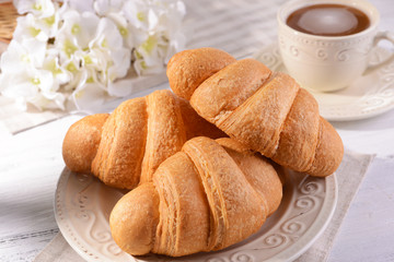 Delicious croissants on plate on table close-up