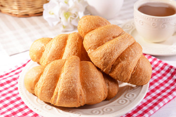 Delicious croissants on plate on table close-up