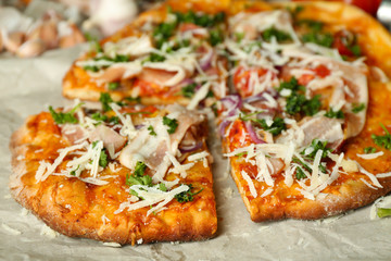 Tasty pizza on paper close up