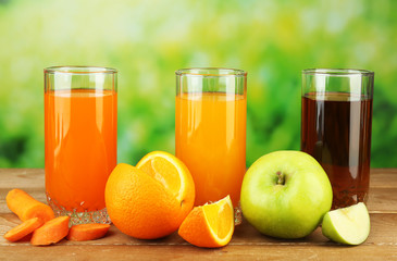Assortment of healthy fresh juices on wooden table, on bright background