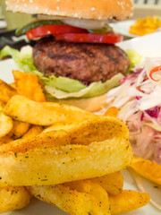  Beef burger with french fries and sliced raw cabbage