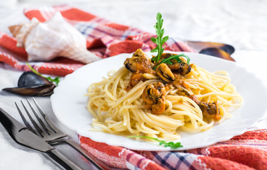 Pasta with mussels with tomatoes and arugula.
