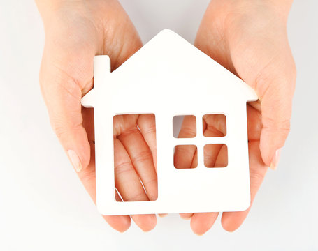 Female hands with model of house isolated on white