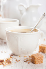 Cup of coffee with sugar cubs and milk jug