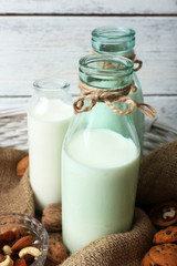 Milk in glassware with walnuts and cookies on wooden background
