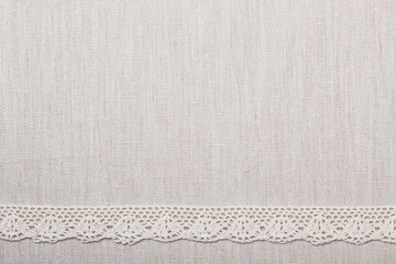 Lace ribbon on linen cloth background