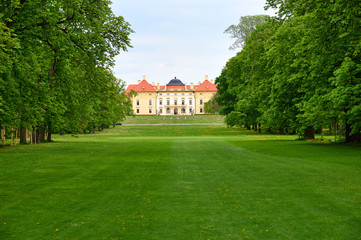 Fototapeta na wymiar Historic chateau with green trees and lawn in spring