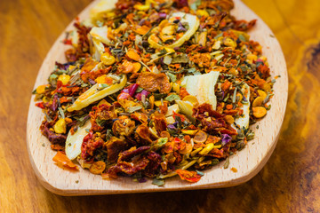 Colored spices for pasta mix on wooden spoon