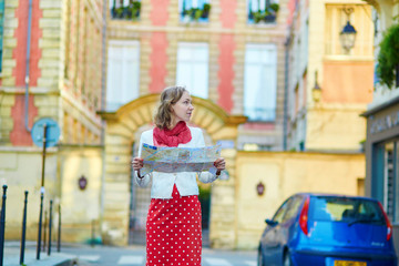 Young beautiful female tourist with map in Paris