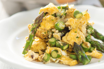 Green asparagus and eggs on wooden background