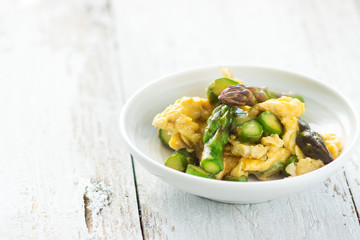 Green asparagus and eggs on wooden background