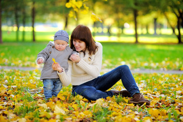 Fototapeta premium Young mother with her little baby boy n in the autumn